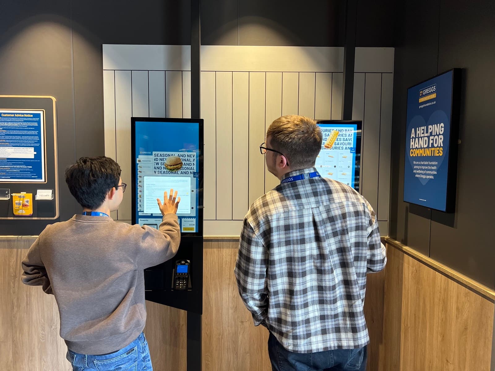 A customer placing an order at a Greggs kiosk